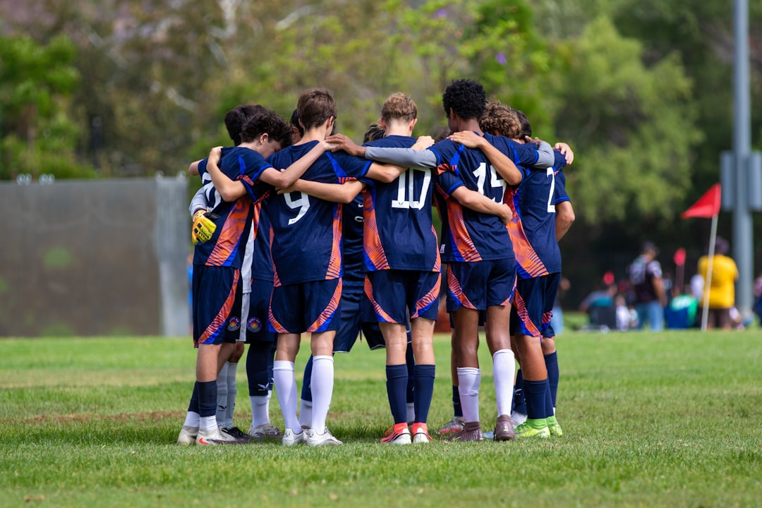 a-soccer-team-huddles-together-on-a-green-field-lwj0mku40hw