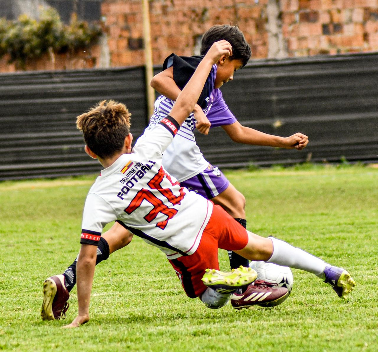 Action-packed soccer match with young boys in dynamic play on a green field.